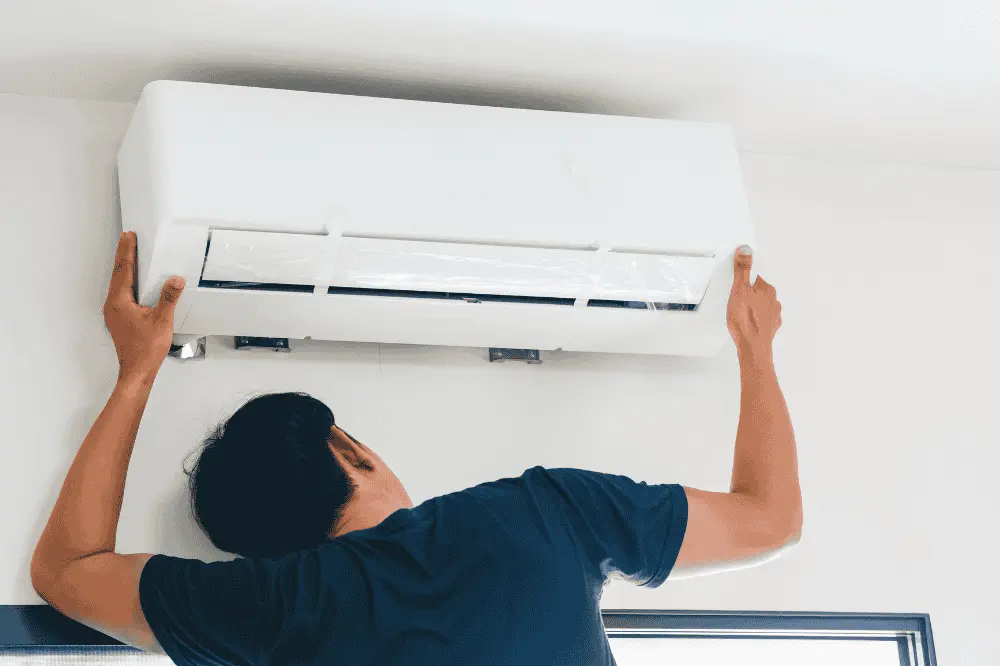 Teknisi memasang unit indoor AC baru